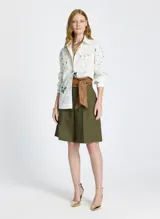 Bermuda verde oliva de lino, con corte entallado, cinturilla con trabillas, cierre de cremallera frontal con corchetes, pliegues delanteros, bolsillos de parche y un cordón a juego.