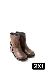 Botas de caña baja en ecocuero color marrón, con diseño de estilo western que incluye una tira decorativa con hebilla metálica y remaches en el lateral. Poseen una base plana con un pequeño taco cuadrado y costuras reforzadas.