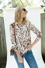 Camisa de fibrana de corte clásico con estampado animal print tipo cebra en tonos chocolate sobre base off-white, mangas largas, cuello camisero y cierre frontal con botones.