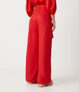 Pantalón acampanado de viscosa color rojo, con trabillas en la cintura, lazo y bolsillos cargo laterales.