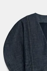 Vestido corto de denim con escote en pico, mangas cortas abullonadas con aberturas y costuras con pespuntes a contraste. Cierre posterior con cremallera.