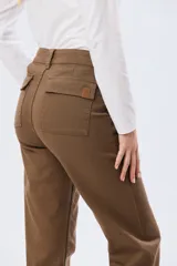 Pantalón de gabardina marrón, de corte recto con pinza en el bajo y detalles de botones en los tobillos.