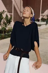 Top de punto color verde, con cuello redondo y mangas cortas anchas de corte holgado.