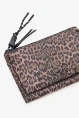 Billetera o neceser grande con estampado de leopardo en tonos marrones y negros. Posee dos cierres principales y un tirador de cordón trenzado blanco y negro con un dije en forma de corazón negro.