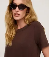 Vestido corto marrón oscuro, estilo camiseta, con escote redondo, mangas cortas y bolsillos laterales. El bajo es redondeado.