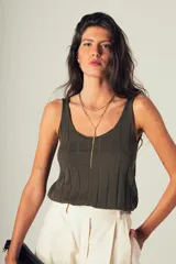 Musculosa de tejido canalé color verde oscuro, confeccionada en 100% algodón, con escote redondo y calce que acompaña el cuerpo.