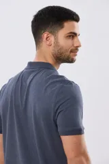 Remera polo de manga corta en color azul melange, con cuello camisero, cierre frontal de dos botones y pequeño bordado en el pecho.