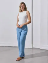 Pantalón celeste de lyocell, corte ancho, con pretina elastizada con lazo de ajuste, bolsillos verticales y ruedo desflecado.