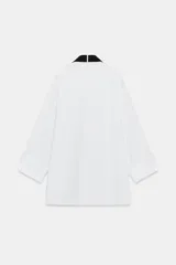 Camisa oversize de algodón con cuello redondo y solapa, manga larga con puño con vuelta y hombro caído. Presenta detalle de tablas en el delantero, cierre frontal con botones ocultos y corbata a contraste incluida.