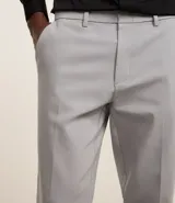 Pantalón de vestir gris claro, corte slim, con trabillas para cinturón, cierre tradicional, bolsillos laterales y traseros.