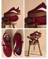 Zapatillas color bordó con plataforma de suela marrón, detalles en blanco en los laterales y en la parte trasera. Cierre de cordones.