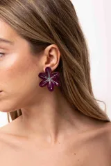 Aro en forma de flor de color bordó con diseño central de destellos plateados con glitter.