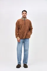 Buzo de sherpa con textura capitoneada, diseño de medio cierre y cuello alto en color beige contrastante. Presenta un calce holgado, mangas largas con puños elásticos y bolsillos laterales.