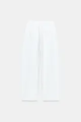Pantalón barrel color azul marino, de tiro bajo, pernera holgada con diseño redondeado que se estrecha hacia el tobillo, con bolsillos delanteros y cierre frontal.
