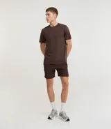 Bermuda deportiva de hombre color marrón, con cintura elástica ajustable mediante lazo y estampa heat print. Confeccionada en tejido de poliéster de secado rápido, diseñada para brindar comodidad y libertad de movimiento durante la actividad física.
