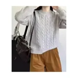 Buzo de punto blanco de manga larga con diseño trenzado y cuello redondo.