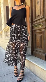 Top negro de lino y viscosa, con breteles finos y corte cruzado con volado lateral. Se ata y regula en la espalda.
