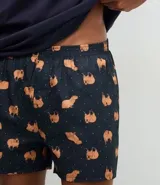 Conjunto de pijama masculino compuesto por una remera de cuello redondo y manga corta con estampa localizada de carpincho, y una bermuda con cintura elástica y estampado de carpinchos en repetición.