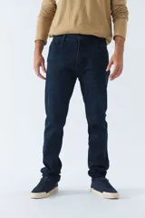 Pantalón de jean corte regular con tiro medio, diseño clásico de cinco bolsillos, cierre frontal con botón y bragueta, y trabillas para cinturón.