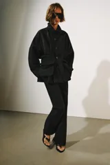 Chaqueta ZW Collection de color negro, con cuello solapa, manga larga y bolsillos delanteros de plastrón con solapa. Presenta cierre frontal con botones y bajo recto.