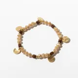 Pulsera elástica con cuentas facetadas color beige, separadores dorados, cuentas cuadradas de madera marrón y dijes redondos dorados.