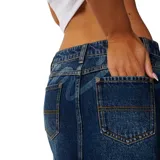 Minifalda de denim azul oscuro con efecto lavado, diseño de tiro bajo y bolsillos delanteros clásicos con costuras contrastantes.
