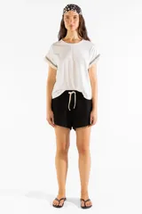 Remera de manga corta color blanco crema con detalle de flecos bordados en las mangas.