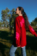 Cárdigan rojo de lana merino con bordados florales fucsia hechos a mano.