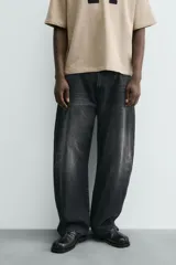 Jeans de hombre, corte balloon fit, tiro medio, confeccionados en denim rígido de algodón. Presentan un efecto lavado con un marcado degradado vertical, cinco bolsillos y cierre frontal con cremallera y botón.