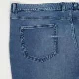 Jean de corte regular color azul oscuro, con cierre de botón y cremallera, y bolsillos delanteros y traseros.