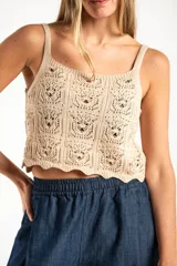 Top de algodón con diseño de tejido crochet y calce al cuerpo, con breteles finos y ruedo con terminación ondulada.