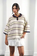 Remera rosa con rayas horizontales azul marino y bordó, cuello tipo polo marrón con botones y mangas cortas amplias.