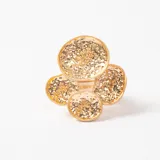 Anillo de diseño moderno en color dorado, compuesto por cuatro discos circulares de diferentes tamaños con textura irregular y acabado brillante.