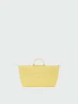 Bolso de viaje XL Longchamp modelo Le Pliage One, color tostado, con doble asa corta y solapa de cuero con botón a presión.