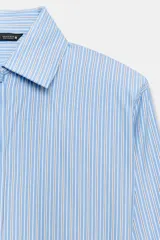 Camisa de manga larga con cuello solapa y hombreras. Presenta un diseño de rayas verticales en tonos azul y blanco, con cierre frontal de botones y puños anchos.