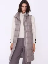 Campera larga sin mangas color visón, con cuello alto y cierre frontal.