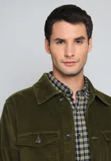 Sobrecamisa negra de pana con cuello clásico, cierre frontal con botones, dos bolsillos de parche con solapa en el pecho y puños abotonados.