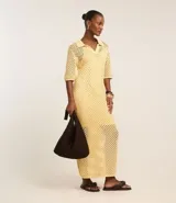 Vestido midi color amarillo pálido con efecto crochet, cuello polo, manga corta y abertura lateral. Confeccionado en algodón BCI más sostenible.