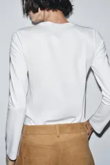 Camiseta de manga larga confeccionada en tejido de punto interlock elástico y flexible, con cuello redondo y bajo recto.