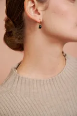 Aros dorados tipo argolla con dije ovalado de piedra negra.