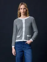 Cardigan de tejido tweed celeste y blanco, con escote redondo, cierre frontal con botones metálicos dorados y bolsillos simulados en el frente.