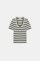 Camiseta de manga corta confeccionada en tejido de algodón con textura rib. Presenta un diseño a rayas horizontales en color blanco y negro, con un escote redondo pronunciado y bajo recto.