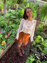 Falda corta tipo pareo confeccionada en cuero color camel, con diseño envolvente ajustable mediante lazos laterales.