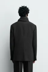 Blazer de corte regular confeccionado en tejido de lana italiana. Presenta cuello con solapas de muesca, cierre frontal de un botón, bolsillos laterales con solapa y bolsillo de vivo en el pecho. Incluye aberturas en la espalda y forro interior.