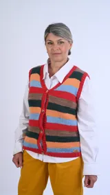 Chaleco de punto artesanal tejido a mano en lana 100% merino, con diseño de rayas horizontales en tonos terracota, verde, mostaza y azul.