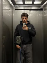 Canguro negro con capucha y bolsillo tipo canguro, de corte regular y confección en mezcla de algodón y poliéster. En la parte posterior presenta una estampa grande en tono gris con la inscripción "Killing in the name of" y una frase complementaria.