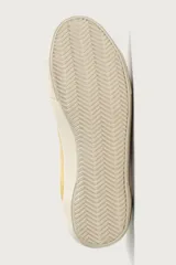 Zapatilla de estilo retro fabricada en una combinación de piel con acabado serraje y algodón, en tonos marrón y amarillo, con suela contrastada.