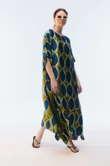 Kaftan maxi amplio de color amarillo, con escote redondo, mangas cortas y ruedo irregular. Presenta un diseño estampado a cuadros con efecto teñido.