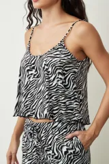 Conjunto de top y short con estampado de piel de serpiente en tonos beige y negro. El top es de tirantes finos y corte holgado. El short es de corte holgado con cintura elástica ajustable.