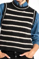 Chaleco de punto negro con rayas horizontales color crema, cuello alto y corte ajustado.